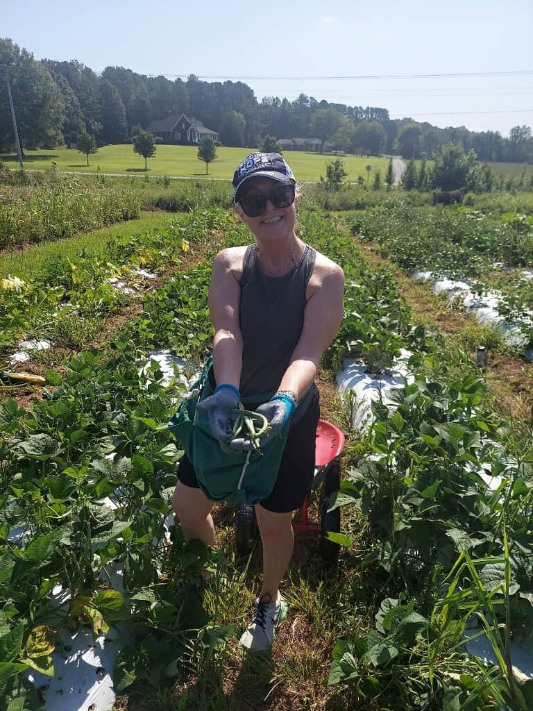 Woman fighting hunger by working in Project Grow. Farming vegetables that will then go to feed people facing hunger. 