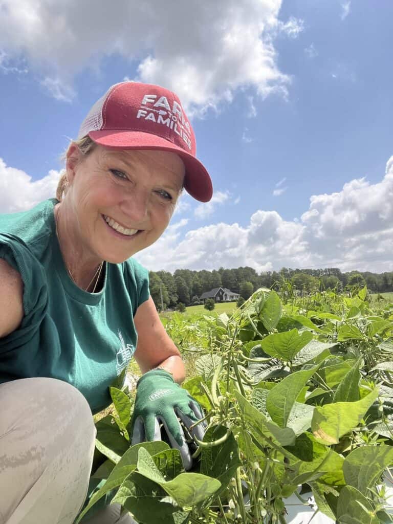 Woman fighting hunger by working in Project Grow. Farming vegetables that will then go to feed people facing hunger. 